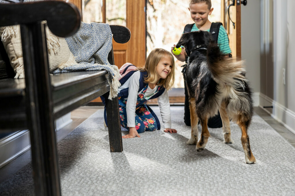 Kids plying with dog on carpet flooring | Vic's Carpet & Flooring